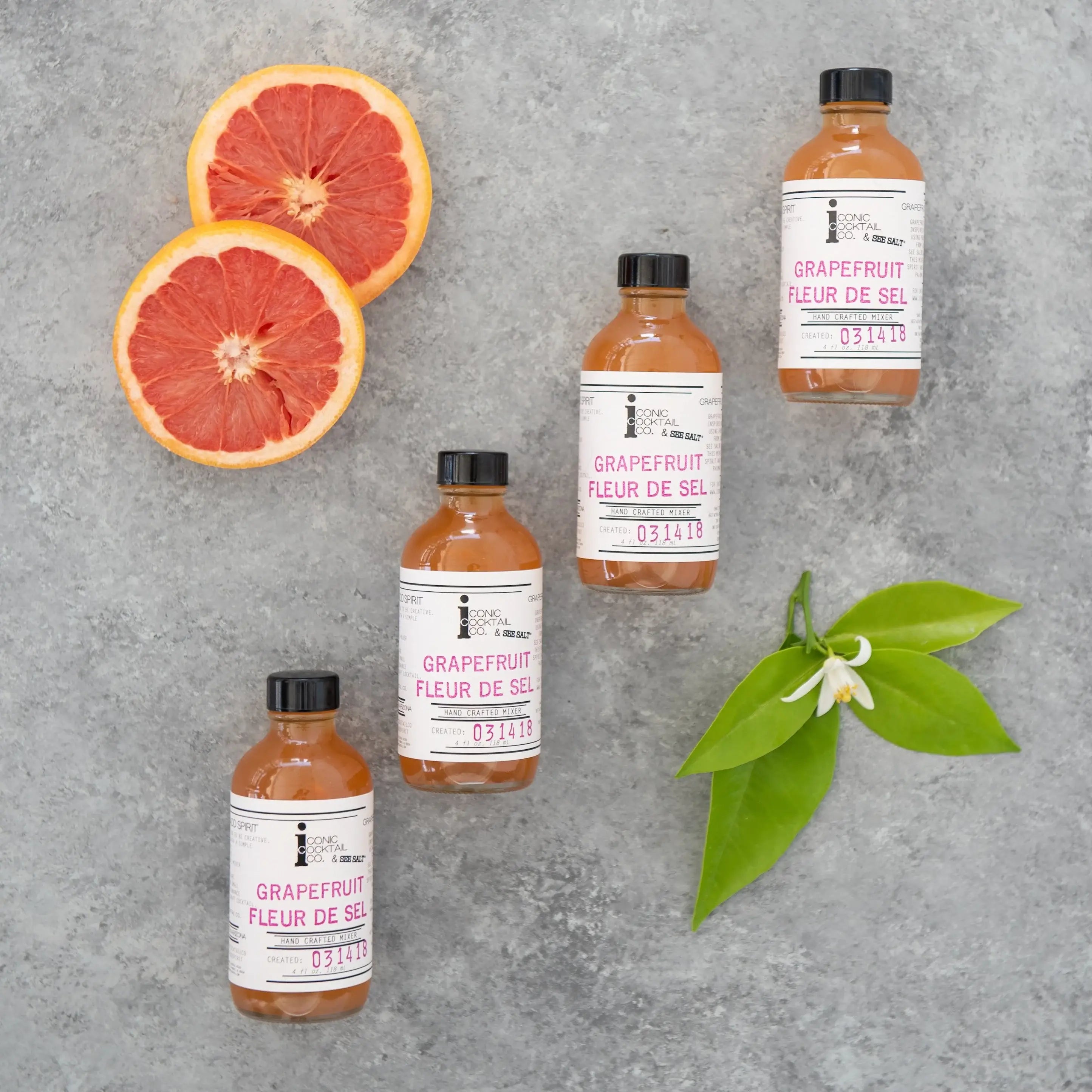 Grapefruit-based products including bottles, sliced grapefruits, and a leaf on a gray background