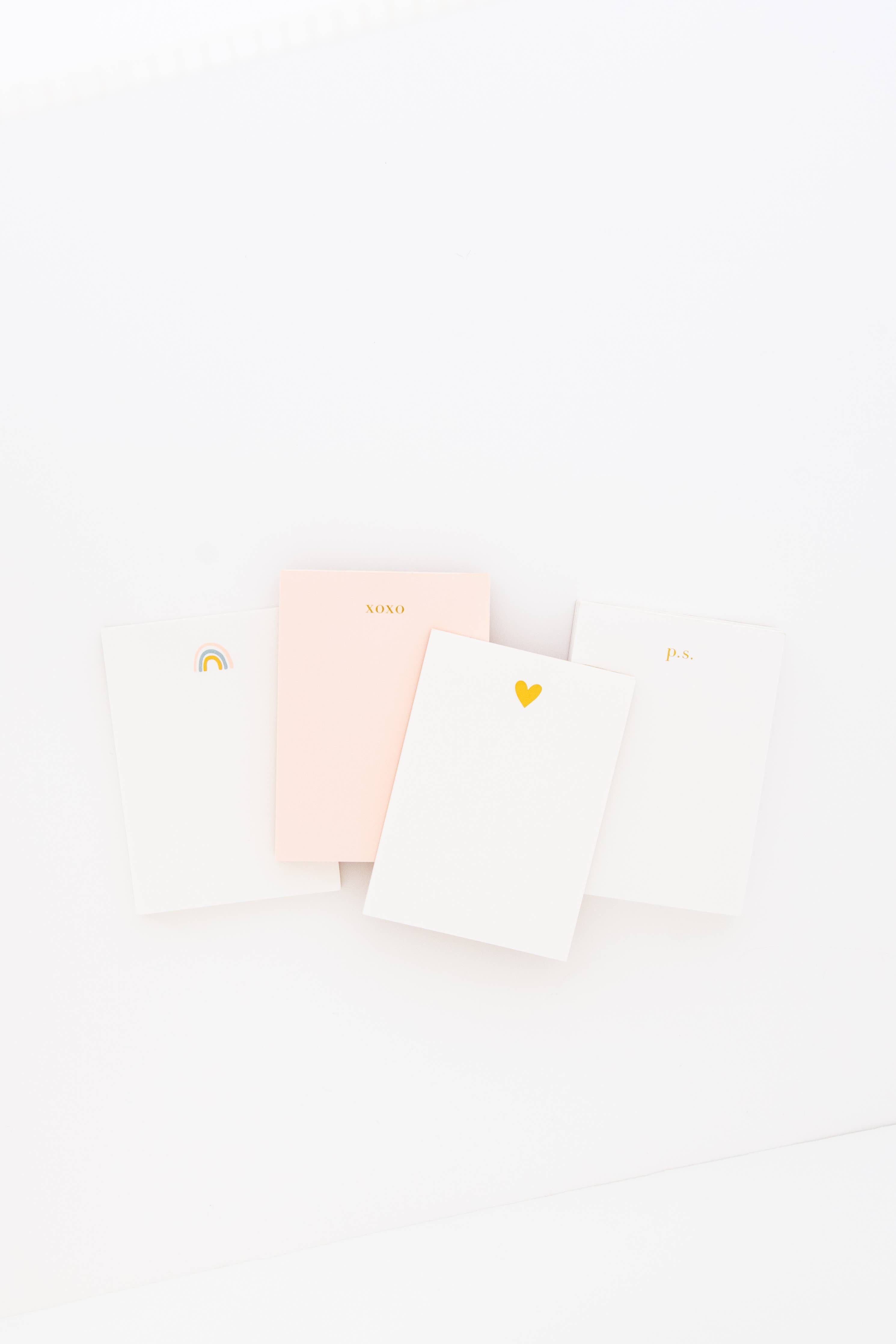 Stack of notebooks with gold heart design on top notebook.