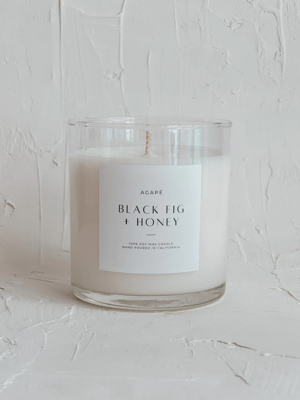 Candle in a glass jar with a label on a light background