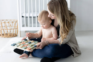 A woman and child playing with ABC puzzle