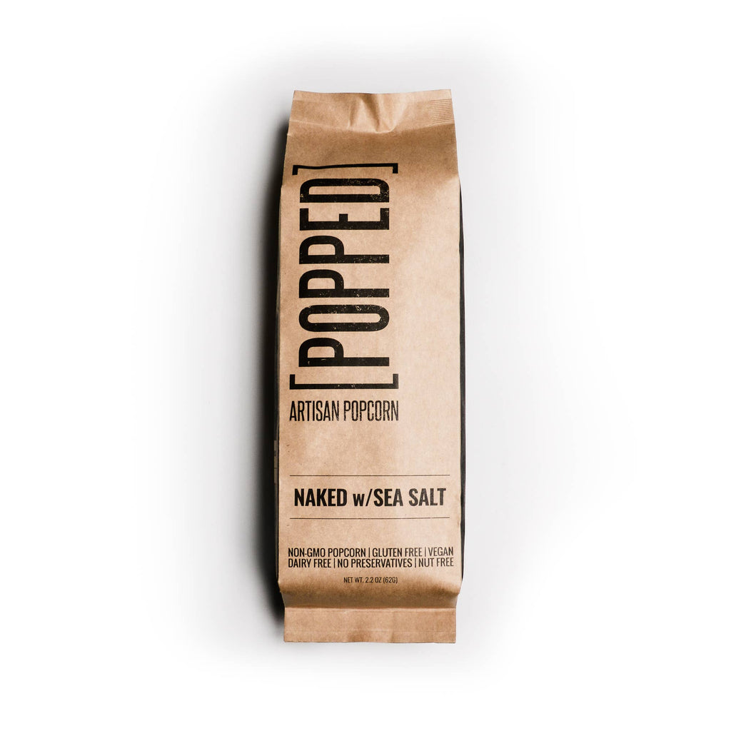 Kraft paper bag of 'Popped' artisan popcorn with 'Naked w/Sea Salt' text on a white background