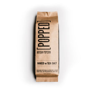 Kraft paper bag of 'Popped' artisan popcorn with 'Naked w/Sea Salt' text on a white background