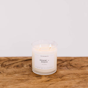 Candle labeled 'Desert Agave' from Calvin Wax Co on a wooden surface with a white background