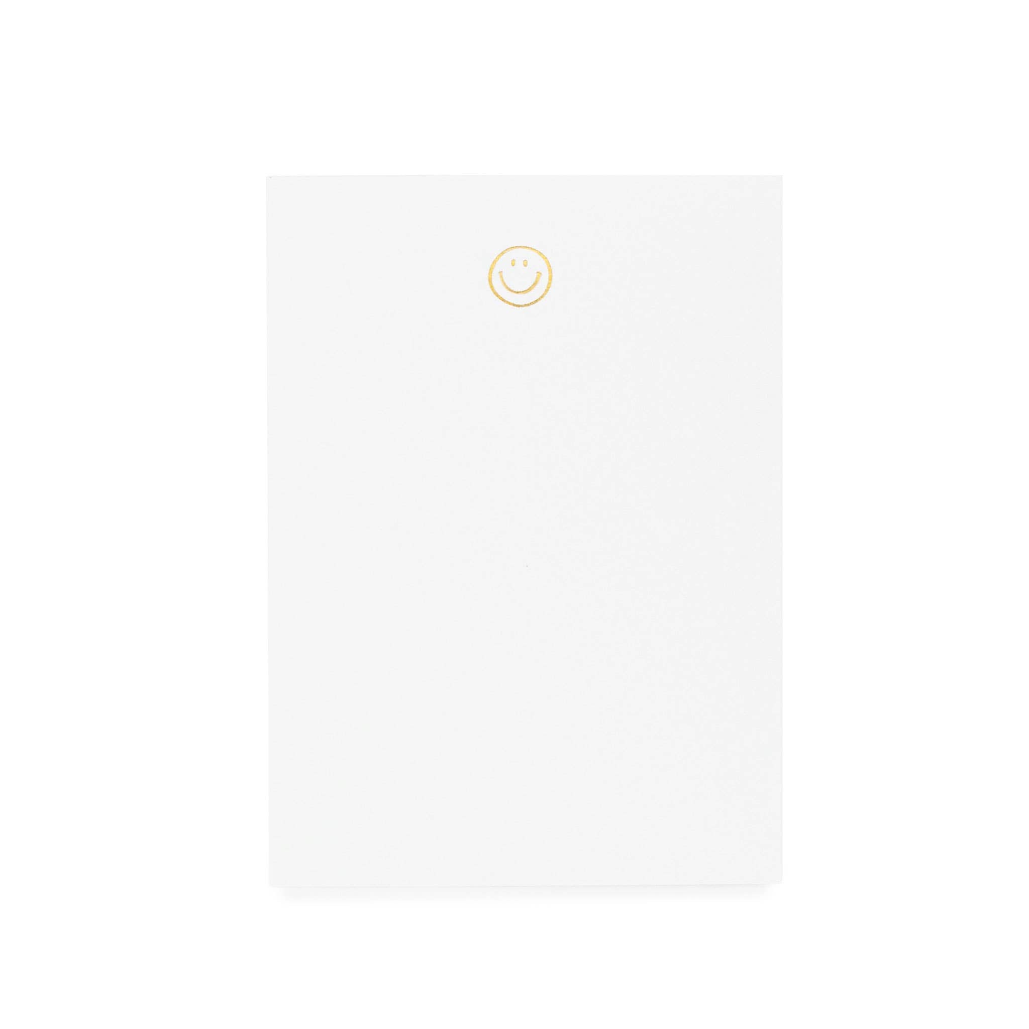 Blank white notebook with a yellow smiley face in the center.